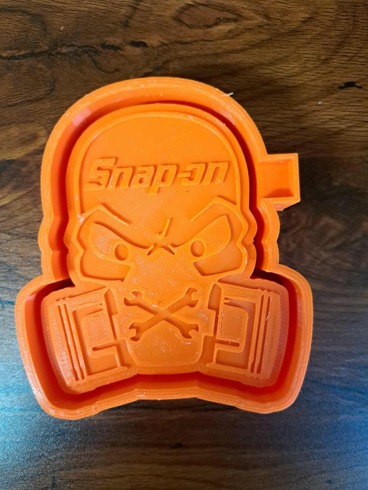 Orange 3d mold with a face mask design on a wooden surface used to make silicone molds