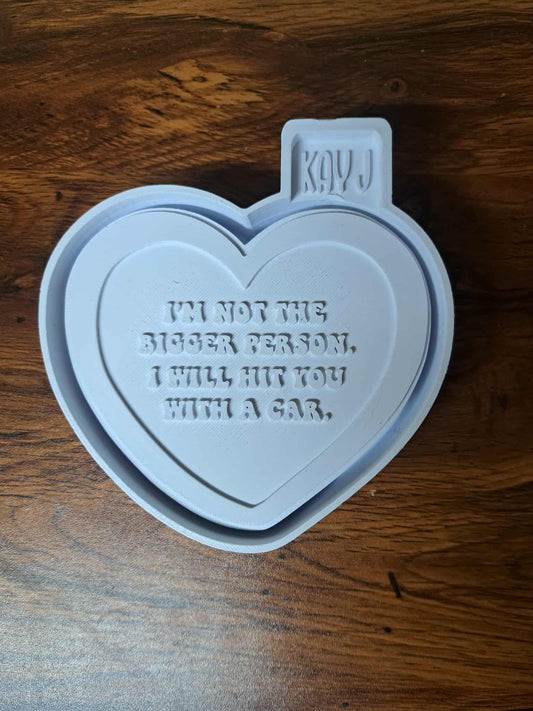 Heart-shaped 3d mold housing with text on a wooden surface used to make silicone molds