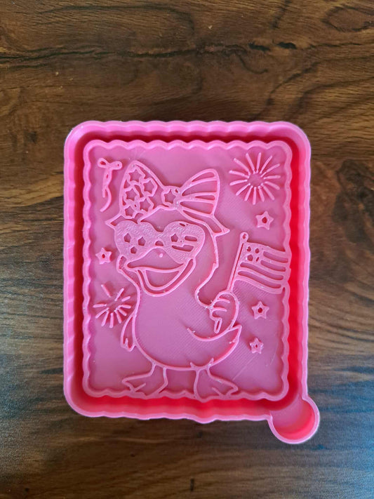 Pink 3d mold housing with a patriotic duck design on a wooden surface used to sell silicone molds