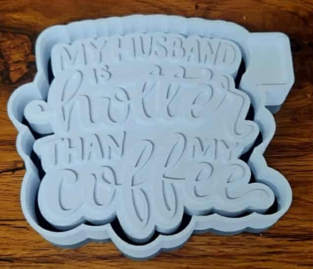Gray 3d mold housing with "my husband is hotter than my coffee" text on a wooden surface used to sell silicone molds