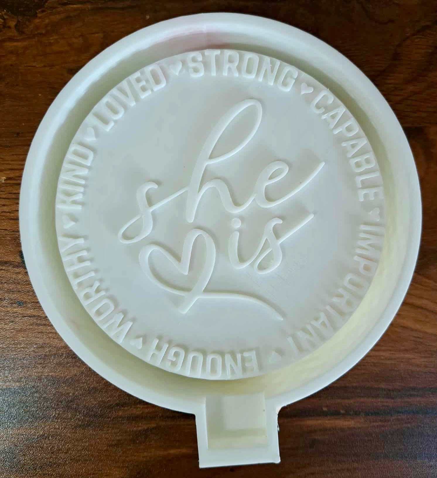 3D mold housing with 'she is' text on a wooden surface used to sell silicone molds