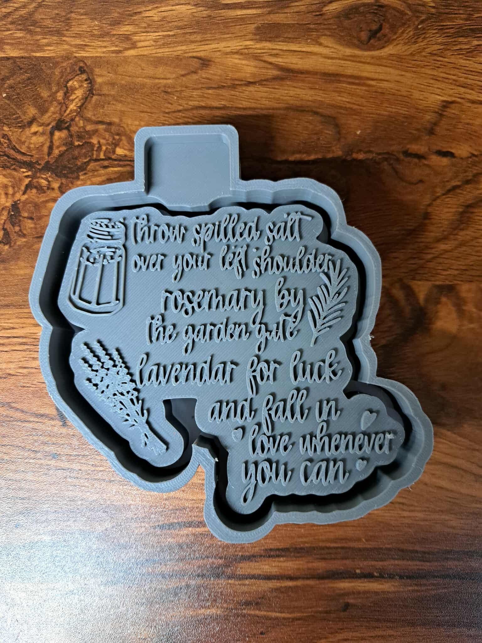 Gray 3D Housing with text about spilled salt on a wooden surface used to make silicone molds
