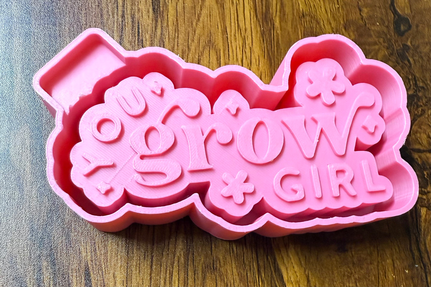 Pink 3d housing with 'You Grow Girl' text on a wooden surface to be purchased as a silicone mold