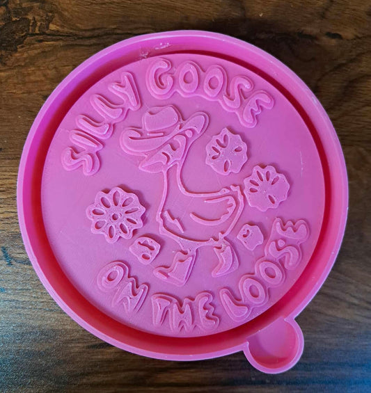 Pink 3d mold housing with 'Silly Goose on the Loose' design on a wooden surface used to sell silicone molds